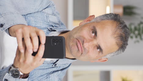 Vertical-video-of-Happy-man-texting-on-the-phone.-Smiling.